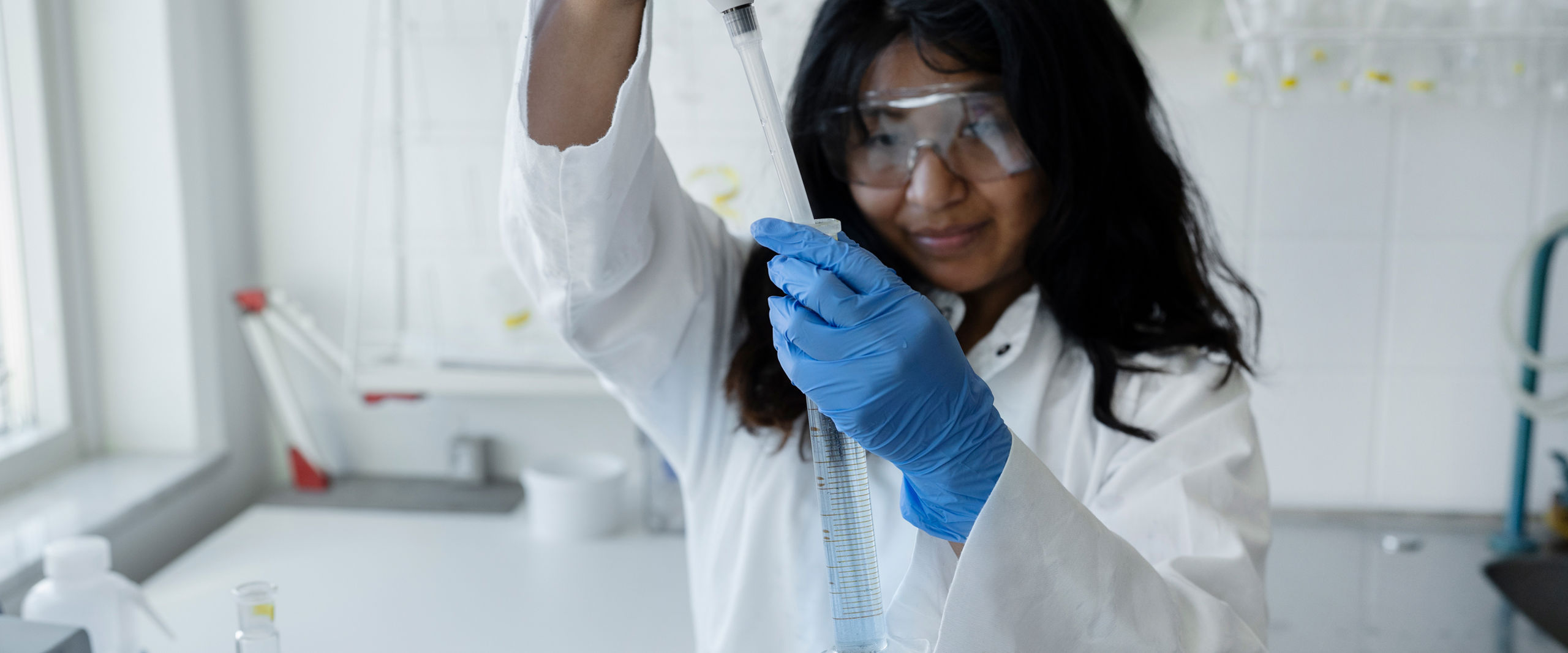 En kvinna håller upp ett provrör med vatten i ett laboratorie.